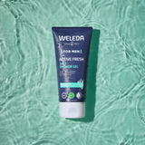 Tube of Weleda Men’s Active Fresh 3 in 1 Shower Gel floating on rippled green water.