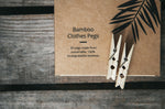 2 Wild and Stone bamboo laundry pegs on top of their cardboard box on a grey wooden table