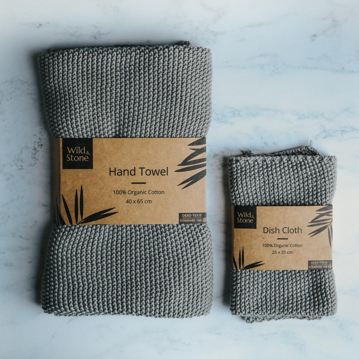 Wild and Stone dove grey hand towel and dish cloth folded on a white marble background