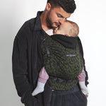An adult carrying a baby in the Love Radius HoodieCarrier 2 - Wild Camo. 