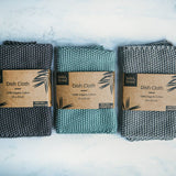 3 Wild and Stone organic cotton dish cloths laid out in a line on a white marble background