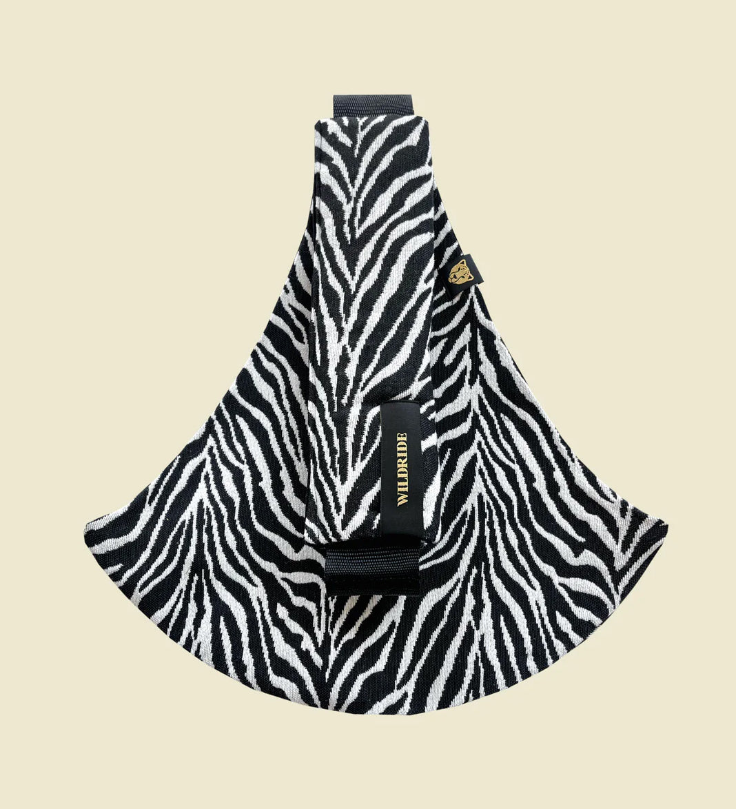 Wildride toddler carrier in black zebra stripe. A 100% cotton seat stylish hip carrier for babies in a zebra skin design