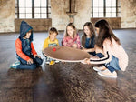 Children rolling a ball on a Wobbel 360 Balance Board with Felt on a wooden floor