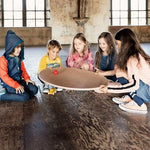Children rolling a ball on a Wobbel 360 Balance Board with Felt on a wooden floor