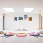 Wobbel Beech Wood balance boards set out in a semi circle in a white mirrored room