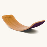 Wobbel Original bamboo balance board with aubergine wool felt backing shown side-on.