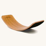 Wobbel Original bamboo balance board with black wool felt backing shown in curved position.