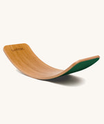 Wobbel Original bamboo balance board with foliage green wool felt backing shown in curved profile