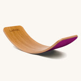 Wobbel Original bamboo balance board with raspberry wool felt backing displayed in a soft curve.