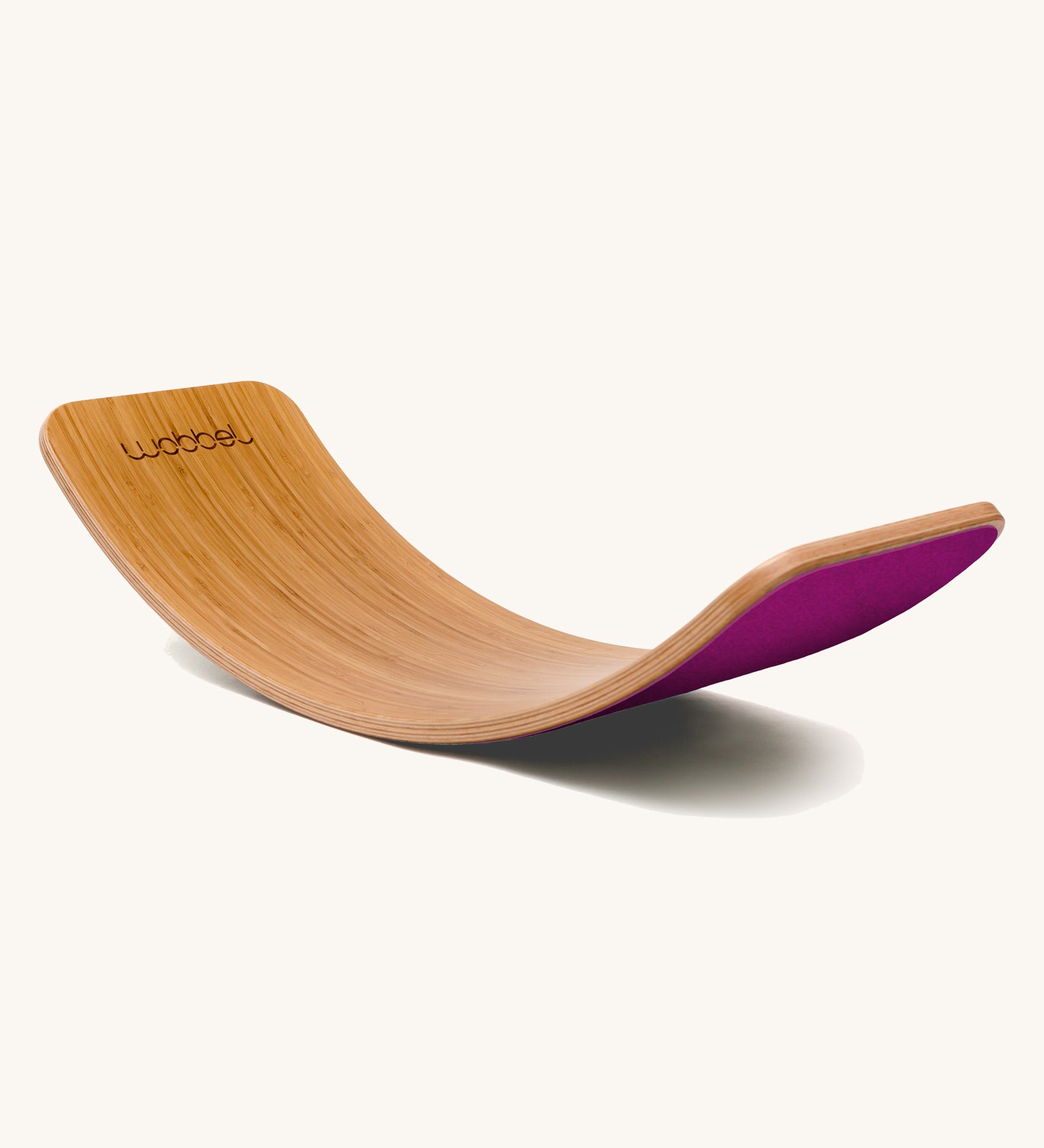 Wobbel Original bamboo balance board with raspberry wool felt backing displayed in a soft curve.