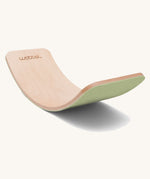 Wobbel Original beech balance board with green recycled felt backing shown in a curved rocking position