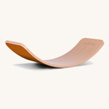 Wobbel Original beech balance board with rust wool felt backing displayed in curved profile.