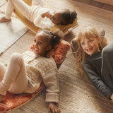 Kids laying on some Wobbel balance boards with different coloured accessory deck cushions and pillows