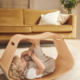 Child laying on their back inside the Wobbel plastic-free wooden Big Up balance box