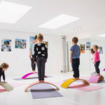 Group of children using Wobbel Beech Wood balance boards for yoga