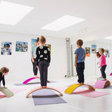 Group of children using Wobbel Beech Wood balance boards for yoga