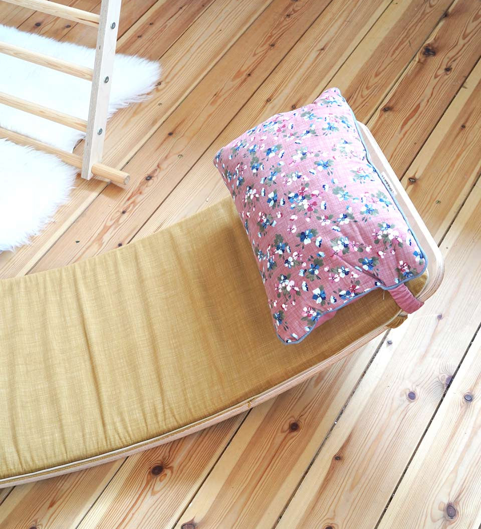 Close up of the Wobbel eco-friendly deck and pillow cushion accessories on a Wobbel XL balance board on a wooden floor