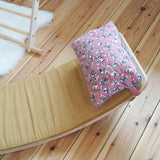 Ochre XL deck on a Wobbel board with a floral pillow on a wooden surface  