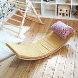 Ochre XL deck on a Wobbel board with a floral pillow on a wooden surface next to a Triclimb in the Babipur playroom 