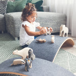 Girl playing with wooden toys on a Wobbel Pro Felt balance board