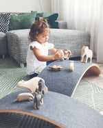 Girl playing with wooden toys on a Wobbel Pro Felt balance board