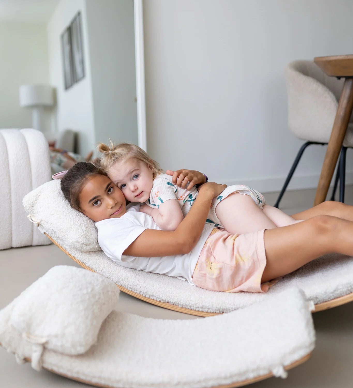 Two children lying on an extra large wobbel board
