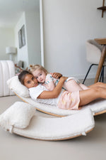 Two children lying on an extra large wobbel board