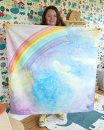 Woman stood holding up the Wondercloths large maxi play silk in the magical sky print