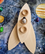 A wooden rocket created using the Grapat petals placed on the Wondercloths Solar System Learning Cloth 