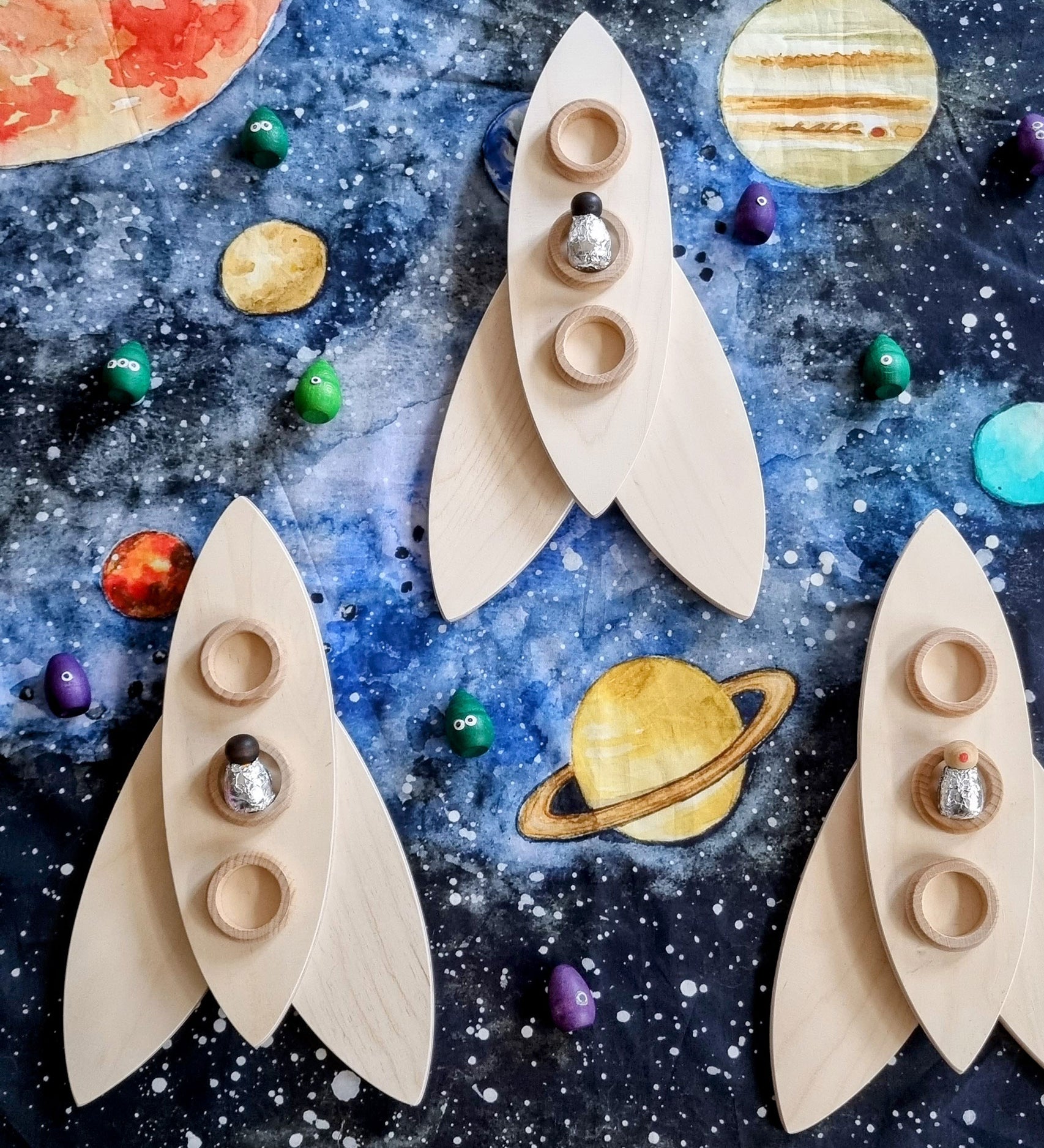 Wooden rockets created using the Grapat petals placed on the Wondercloths Solar System Learning Cloth 