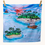 Wonderie Play Cloth featuring the lost island design on a plain background. Hand illustrated lost island theme drawings featuring islands, a volcano, a pirate ship, a parrot and sharks.