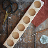 Wooden holder for 6 50ml glass jars, top down view. 