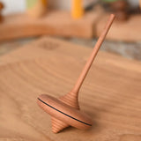 Mader ibis spinning top placed on a an oak spinning plate in the Babipur playroom.