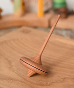 Mader ibis spinning top placed on a an oak spinning plate in the Babipur playroom.