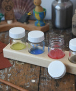 Wooden block holder with 50ml glass jars placed inside with paint in them.  