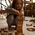 A child stacking natural Wooden Story blocks.