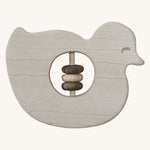 Wooden Story Baby Duck Rattle on a plain background. A baby duck shaped rattle with  cut-out in the middle which has three wooden rings on a wooden rod. 