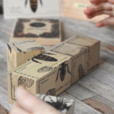 A close up of some of the blocks from the Wooden Story Species of Bees Puzzle Blocks Set. The illustrations of the bees are on all sides of the blocks, a child's hands can be seen on the sides.