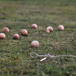 The Wooden Story Boules set laid out on grass outdoors. 