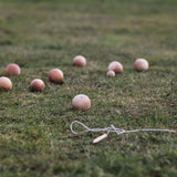 The Wooden Story Boules set laid out on grass outdoors. 