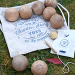 The Wooden Story wooden boules Petanque traditional game set. The pieces from the set have all been placed on top of the cotton drawstring storage bags they come in.  