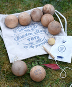 The Wooden Story wooden boules Petanque traditional game set. The pieces from the set have all been placed on top of the cotton drawstring storage bags they come in.  