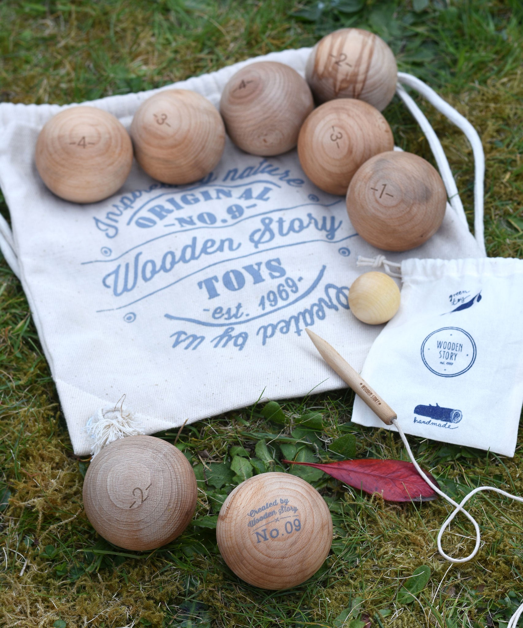 The Wooden Story wooden boules Petanque traditional game set. The pieces from the set have all been placed on top of the cotton drawstring storage bags they come in.  