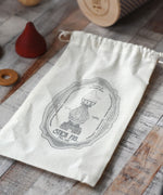 The cotton drawstring storage bag from the Wooden Story Stacking Toy Stick Purple Number 6 Figure.