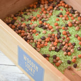 Wooden Story Play Tray filled with coloured dried rice and chick peas.