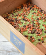 Wooden Story Play Tray filled with coloured dried rice and chick peas.