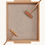 Wooden Story Montessori Sand Tray and Accessories shown on a plain background. The sand is in the tray with the tools. 
