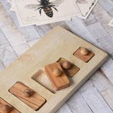The Wooden Story long short puzzle placed on a wooden surface. The third piece has been lifted out of the base frame.