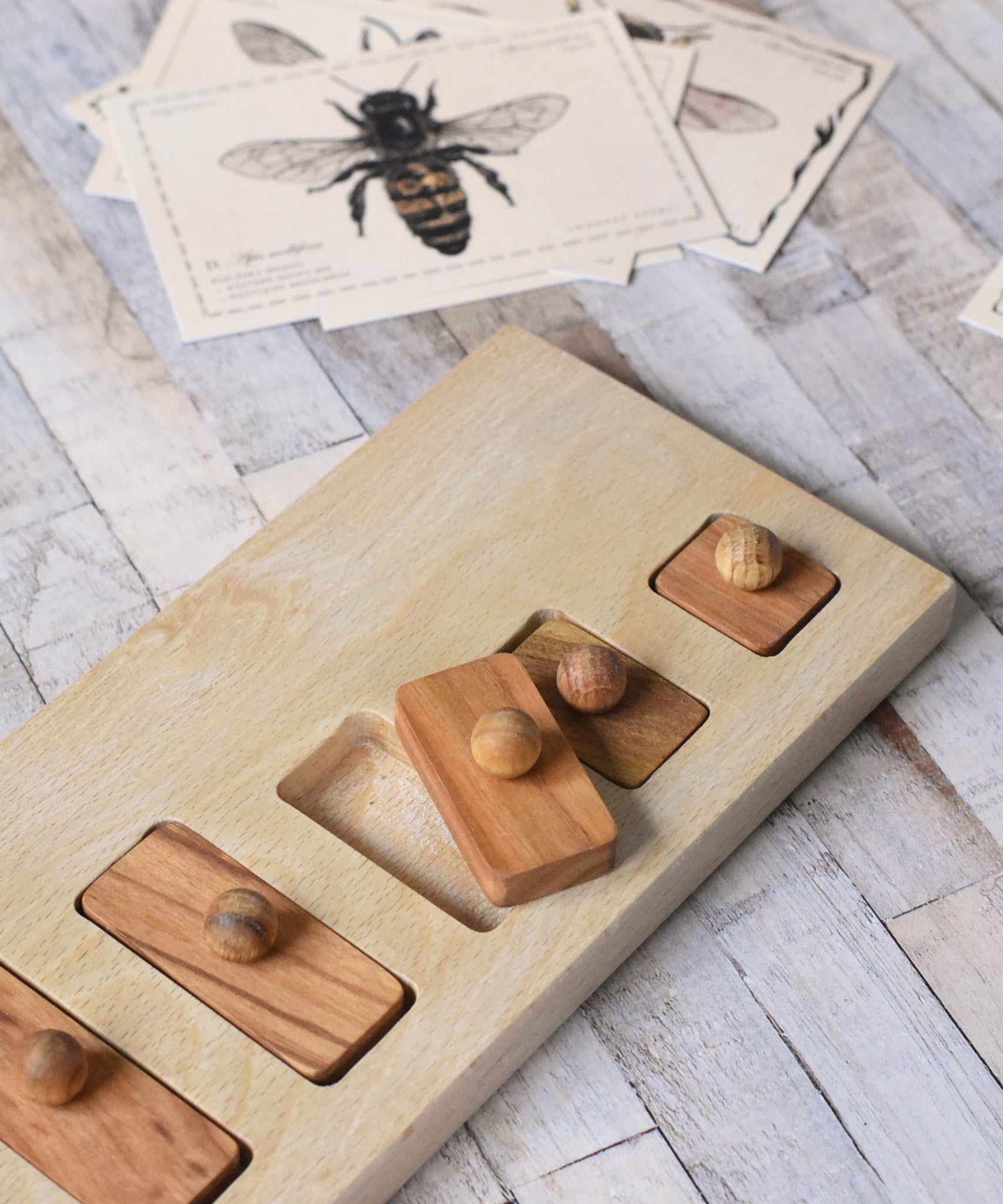 The Wooden Story long short puzzle placed on a wooden surface. The third piece has been lifted out of the base frame.