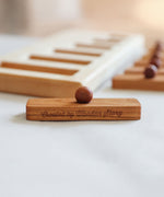 A close up of one of the rectangular shaped pieces that fit in the long short puzzle frame. The words Created by Wooden Story have been etched on the side. 